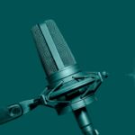 Professional microphone with audio waveform on green background, podcast or broadcast banner with copy space
