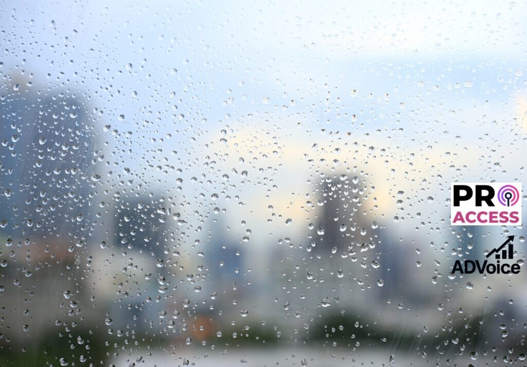 office window covered with rain water. water spray on window. after rain traffic, worker stuck in the office concepts. blur urban skyline background. rainy season concepts.
