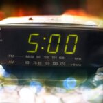 Black digital alarm radio clock.Alarm radio clock indicating time to wake up.Digital clock closeup displaying 5:00 o'clock.