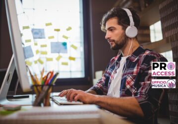 Creative businessman using computer while listening music