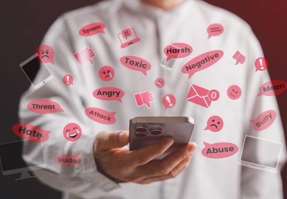 A person using a smartphone surrounded by negative social media comments like hate, bully, and toxic words, representing online harassment, cyberbullying, and digital abuse on the internet.