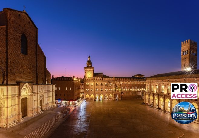 Sunset light bathes Piazza Maggiore in Bologna, highlighting the grandeur of its medieval structures against the dusk sky