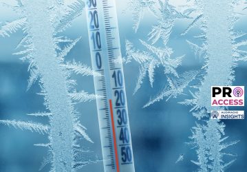 Frosty winter window with ice patterns and a thermometer showing a minus temperature