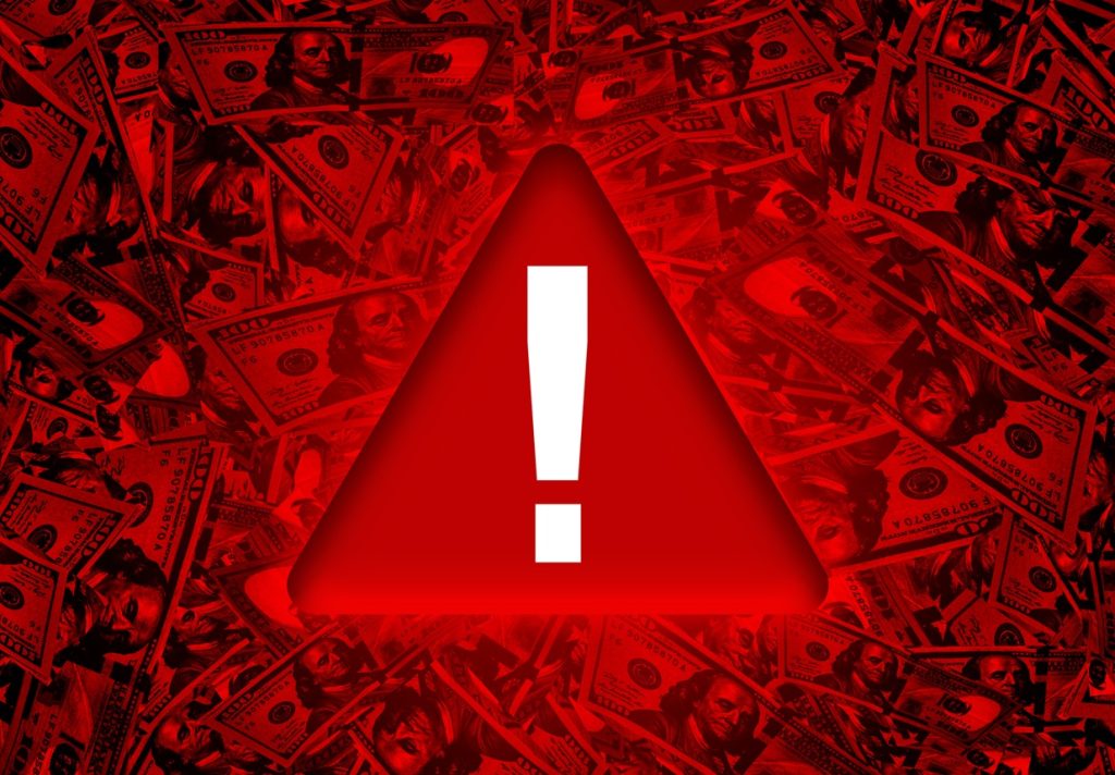 Global Economy Red danger warning sign on bunch of hundred dollar bills
