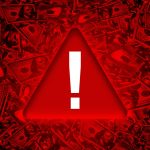 Global Economy Red danger warning sign on bunch of hundred dollar bills