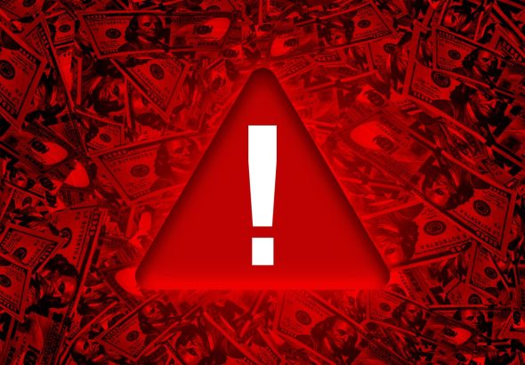 Global Economy Red danger warning sign on bunch of hundred dollar bills