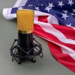A gold microphone stands proudly before the American flag, ready to capture important voices.