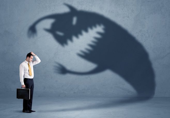 Business man afraid of his own shadow monster concept
