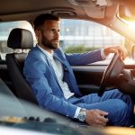 Attractive man in business suit driving car
