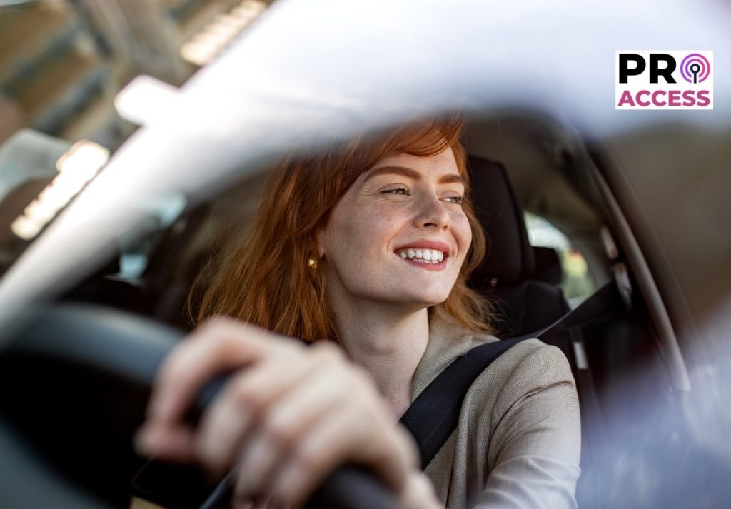 Woman Driving Car Smiling. Redhead Female Driver Behind the Wheel. Automotive Insurance, Safe Driving, and Commuting Concept. Young Woman in Modern Vehicle.